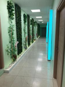 un pasillo con plantas en la pared de un edificio en ROOM'S KARABURUN, en Mordogan