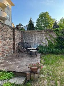 a patio with a table and chairs next to a brick wall at Apartment Gloria 4 NEW in Belgrade