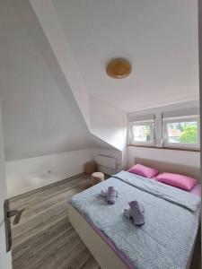 a bedroom with a bed and two pink pillows at Apartment Gloria 4 NEW in Belgrade