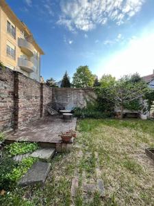 a backyard with a table and a brick wall at Apartment Gloria 4 NEW in Belgrade