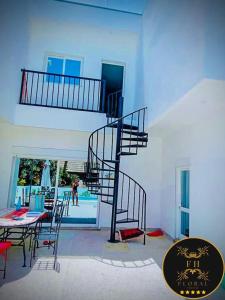 - un escalier en colimaçon dans une chambre avec une table et des chaises dans l'établissement MAISON FLORAL, à Saly Portudal