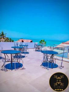 un gruppo di tavoli e sedie sulla spiaggia di MAISON FLORAL a Saly Portudal