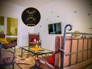 a living room with a bed and a table and chairs at MAISON FLORAL in Saly Portudal