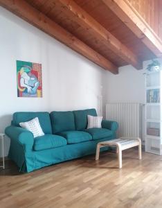 un divano blu in soggiorno con tavolo di Quadrisfera Apartment a Paratico
