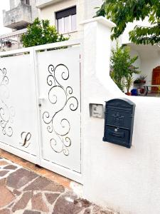 una valla blanca con una puerta y un buzón en Villetta Anastasia, en Francavilla al Mare