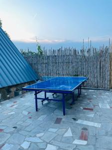 a blue ping pong table sitting on a patio at Unique wooden villa with pool in Olympiada