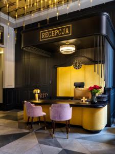 a lobby with a reception desk and two chairs at Golden Queen Aparthotel in Kraków