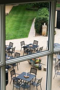 Blick aus einem Fenster auf eine Terrasse mit Tischen und Stühlen in der Unterkunft Fleur de Lys Bampton in Bampton