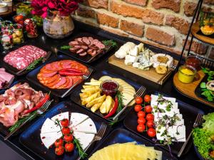 una mesa llena de diferentes tipos de carne y queso en Golden Queen Aparthotel en Cracovia