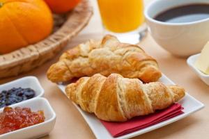 a table with a plate of croissants and other breakfast foods at B&B Luna Blu in Modica