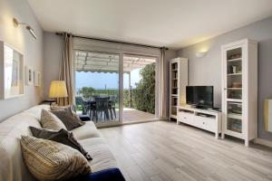 a living room with a couch and a television at Your Vacation Retreat Right On The Beach in Casares