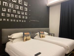 two beds sitting next to each other in a room at M Boutique Hotel Station 18 - Ipoh in Ipoh