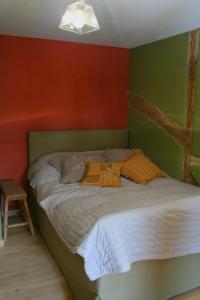 a bed in a room with red and green walls at La ferme Claudlisse in Vielsalm