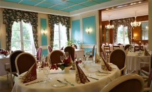 a dining room with white tables and chairs and windows at Hotel-Restaurant Zum Landgraf - Henry Merz in Wartmannsroth +37 photos