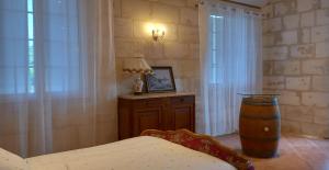 um quarto com uma cama e uma mesa com um candeeiro em L'HERMITAGE D'ALIENOR em Lugon et l’Ile du Carney