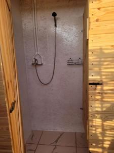 a shower with a hose on a wall in a bathroom at Makeeda Camping in Vama Veche