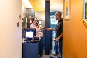 Ein Mann und eine Frau stehen in einem Büro in der Unterkunft C&f hostel in Porto