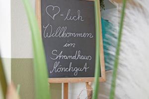 un cartel de pizarra con un corazón escrito en él en Strandhaus Mönchgut Bed & Breakfast Lobbe, en Lobbe