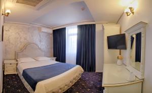 a hotel room with a bed and a television at Hotel Central in Slobozia