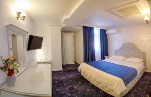 um quarto de hotel com uma cama e uma televisão em Hotel Central em Slobozia