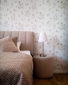 a bedroom with a bed and a lamp on a table at Grâce Boutique Apartments in Halle an der Saale