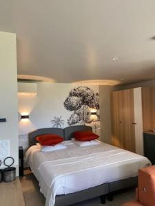 1 dormitorio con 1 cama blanca grande con almohadas rojas en LIS ESTELLO - 4* apartment - Upscale gite in Flayosc, en Flayosc