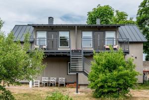 a house with a balcony and a deck at Lapmanni Holiday Home in Haapsalu