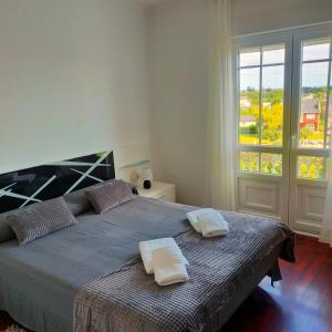a bedroom with a bed with two towels on it at Rocas Brancas in Ribadeo