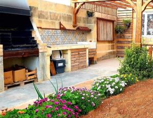 a garden with flowers and an outdoor oven at Ta' Ciangura House of Character in Għajnsielem