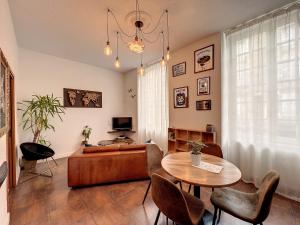 a living room with a table and chairs and a couch at Le Vintage - 15 min FUTUROSCOPE in Poitiers