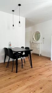 a dining room with a black table and chairs at 2 ZKB Apartment in Mannheim in Mannheim