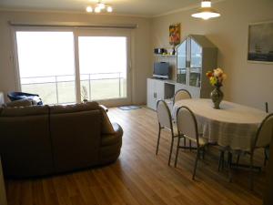 een woonkamer met een tafel en een bank bij Zandvlugge 0303 in Koksijde