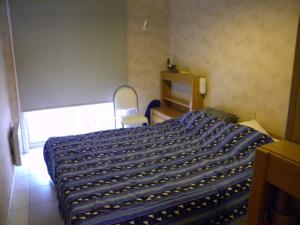 een slaapkamer met een bed met een blauwe deken erop bij Zandvlugge 0303 in Koksijde
