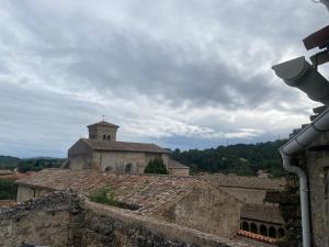 an old building with a church in the background at La P’tite Maison de David in Saint-Hilaire
