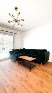 a living room with a green couch and a table at 2 ZKB Apartment in Mannheim in Mannheim