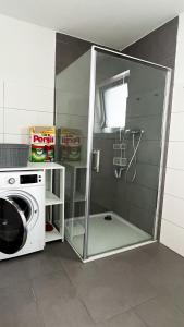 a glass shower in a bathroom with a washing machine at 2 ZKB Apartment in Mannheim in Mannheim