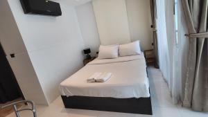 Habitación pequeña con 2 camas y una servilleta. en Serenity Condo Wongamat by Patsamon en Pattaya North