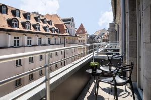 a balcony with two chairs and a table at AMANO Home Leipzig in Leipzig