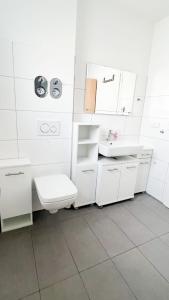 a white bathroom with a sink and a toilet at 2 ZKB Apartment in Mannheim in Mannheim