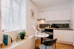 a kitchen with white cabinets and a table and chairs at Bel écrin sur l'île de Nantes - GARE TGV, CHU, CONGRES in Nantes