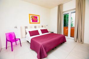 ein Schlafzimmer mit einem rosa Bett und einem rosa Stuhl in der Unterkunft Prime blue suite - Giardini in Riccione