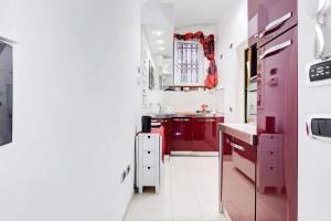 uma cozinha vermelha com balcões brancos e um frigorífico vermelho em Cherì Navona em Roma