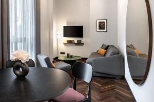 AMANO Home Leipzig في لايبزيغ: غرفة معيشة مع طاولة وكراسي