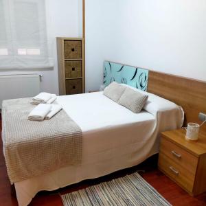 a bedroom with a bed with two towels on it at Rocas Brancas in Ribadeo +5 photos