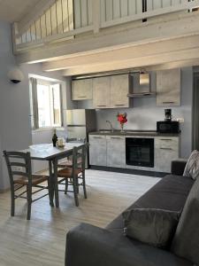 a living room with a table and a kitchen at Casa Castellana Apt 1 e Casa Castellana Apt 2 in Sala Comacina