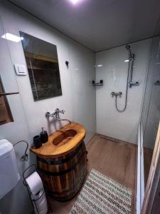 y baño con ducha y lavamanos de madera. en Glamping Paradise Škatlar, en Otočec