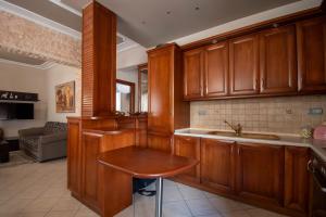 a kitchen with wooden cabinets and a wooden table at Vasiliana's Apartment in Alexandroupoli