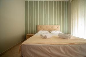 a bedroom with a large bed with two towels on it at Vasiliana's Apartment in Alexandroupoli