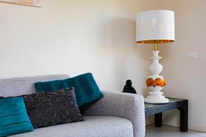 una lampada seduta su un tavolo accanto a un divano di Prime blue suite - Giardini a Riccione