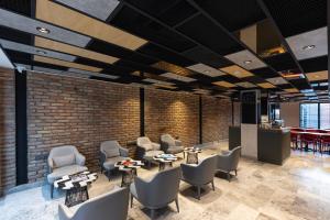 a lobby with chairs and tables and a brick wall at AHG Atlas Hotel Taksim in Istanbul